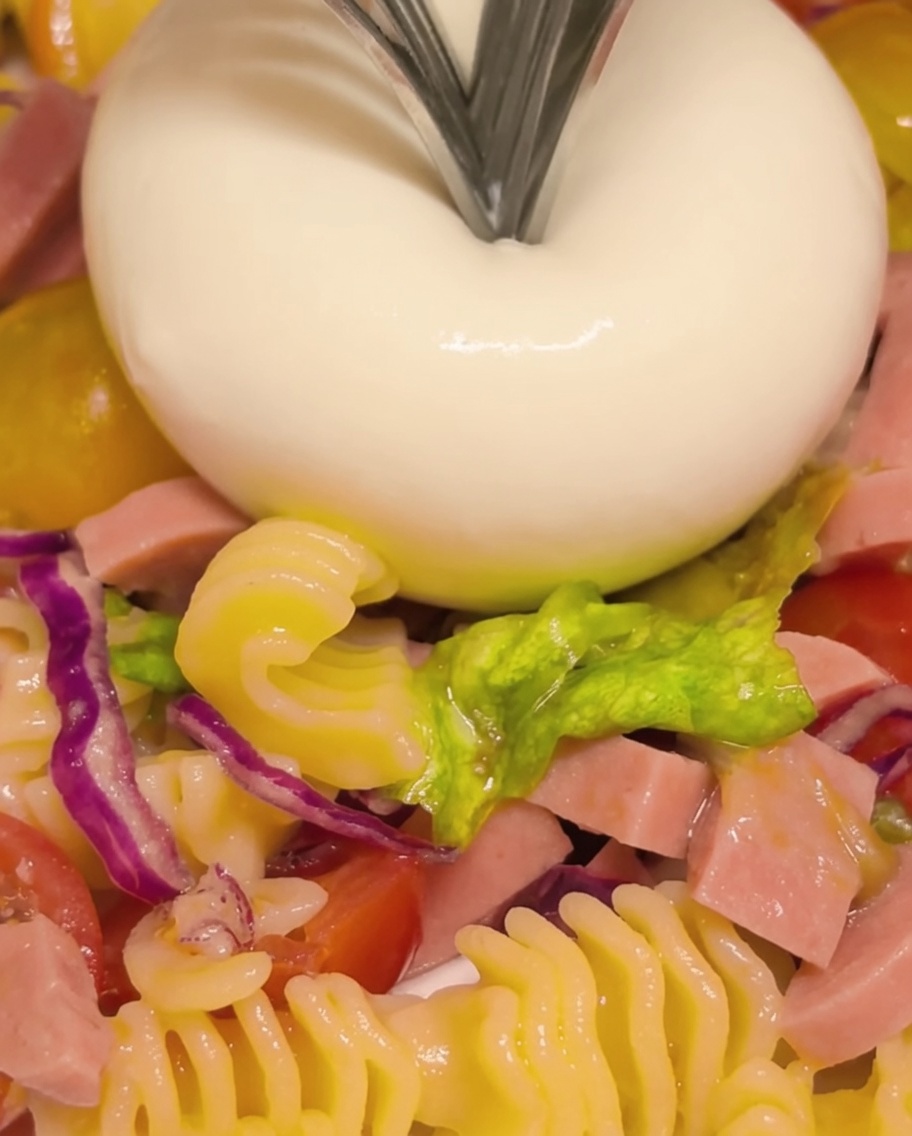 Una burrata aperta con una forchetta per rivelare il centro cremoso che fuoriesce.