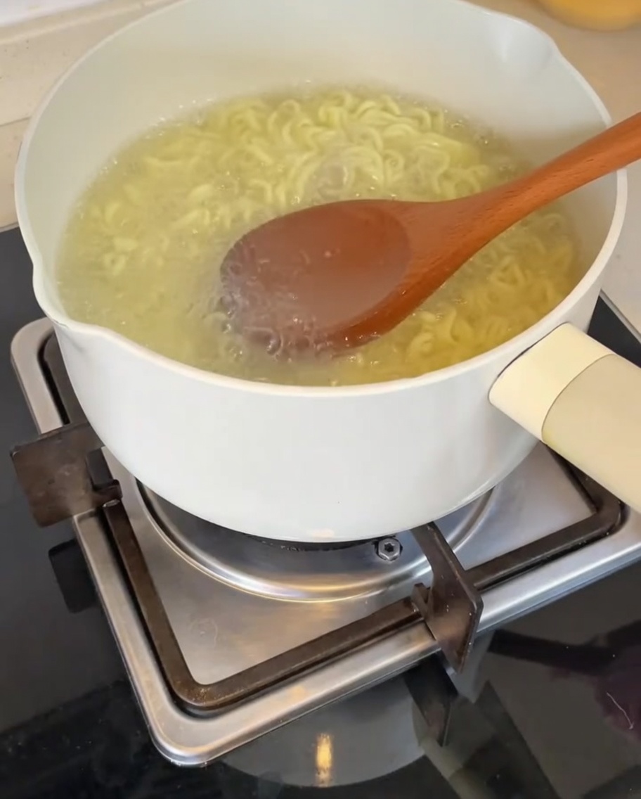 Acqua di cottura dei noodles versata nella ciotola con la base.