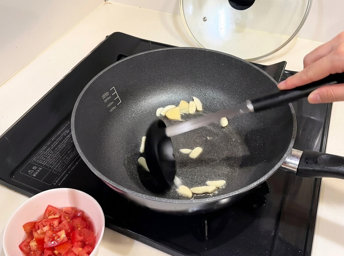 Pezzi di cipolla rossa che si ammorbidiscono in padella con laglio soffritto.
