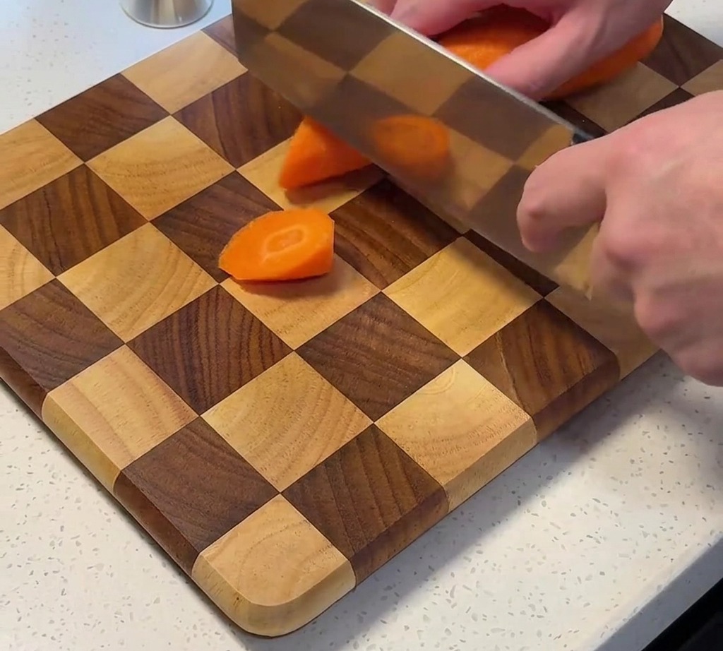 Carote fresche tagliate a pezzi su un tagliere.