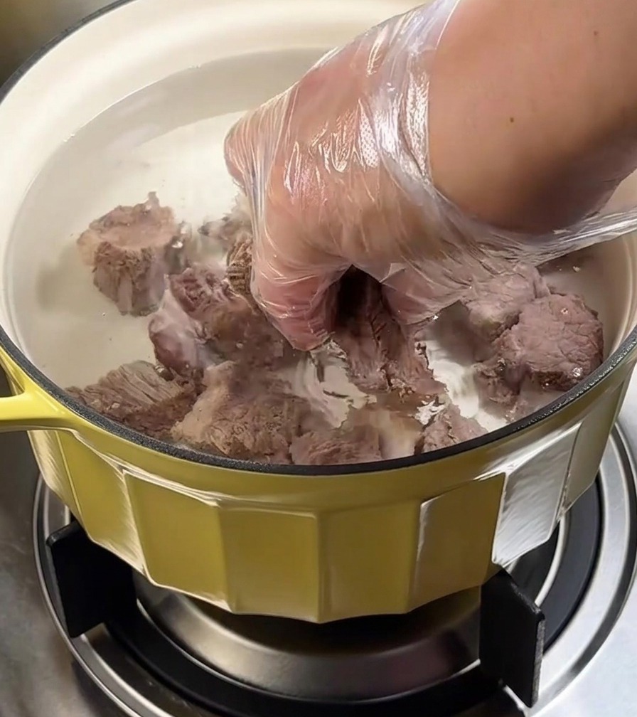 Pentola di manzo in stufatura sul fornello con coperchio.