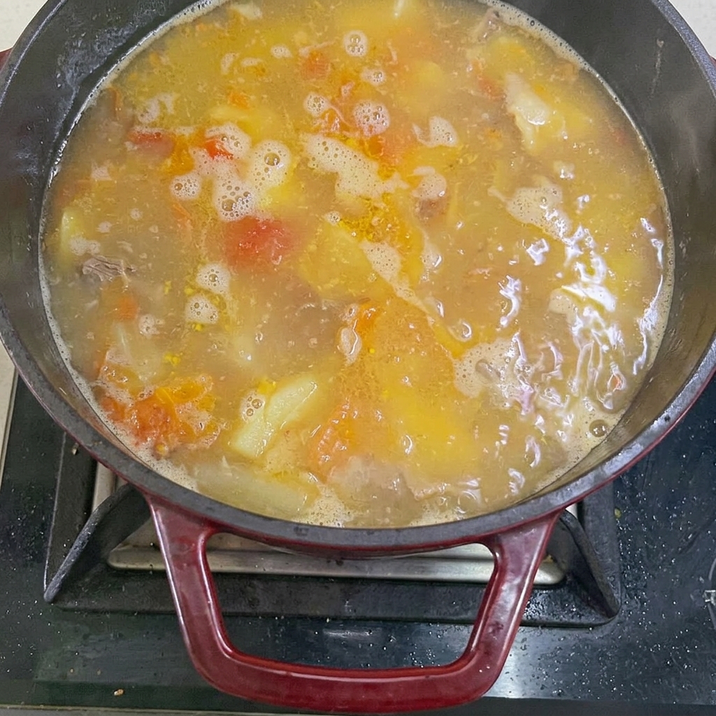Acqua bollente versata nella pentola con manzo e verdure.