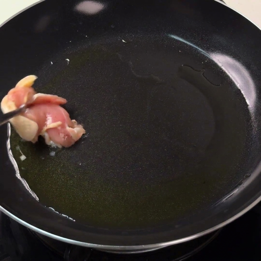 Pezzi di pollo che rosolano in una padella calda con olio fino a doratura.