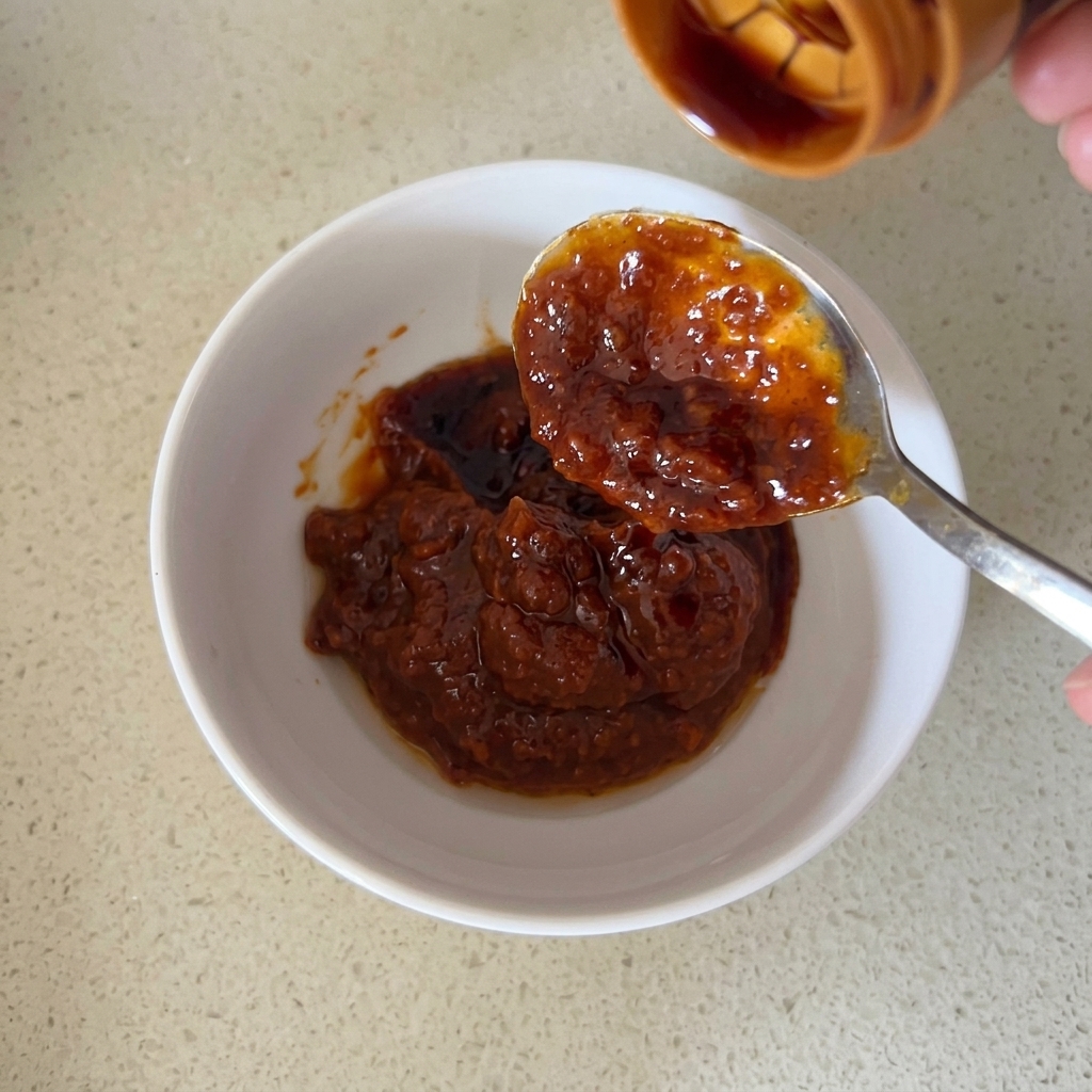 Una ciotola bianca in cui gli ingredienti della salsa vengono mescolati insieme.