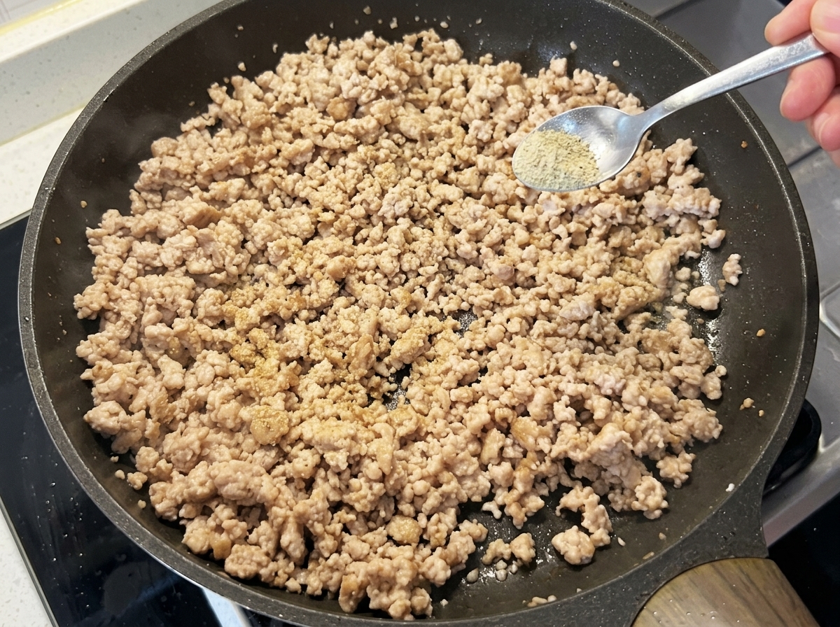Cipollotto e aglio aggiunti alla carne cotta nella padella.