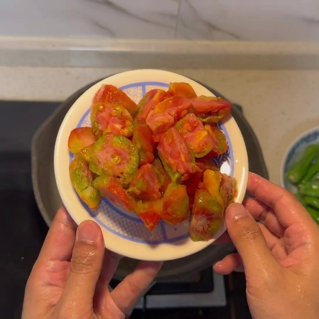 Un piatto con pomodori pelati e tagliati pronti per essere cucinati.