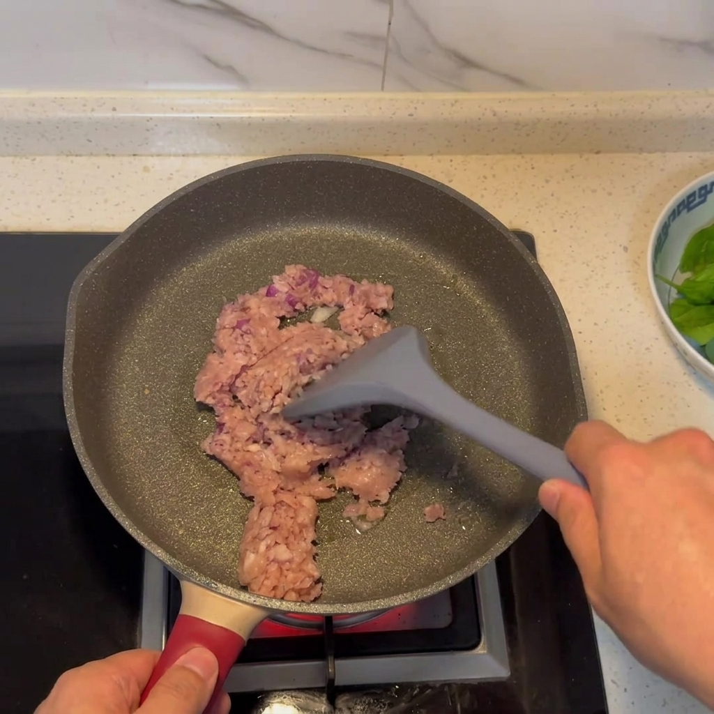 Il composto di carne macinata e cipolla che rosola in padella.