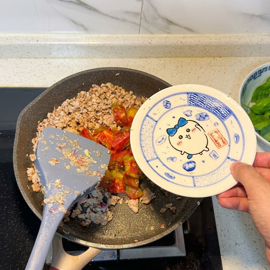 Pomodori tagliati aggiunti alla padella con la carne rosolata.