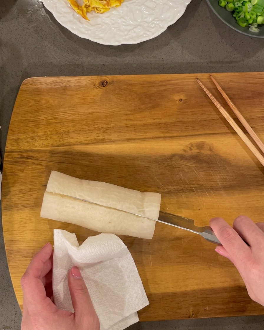 Ravanello bianco cotto tagliato a piccoli rettangoli su un tagliere di legno.