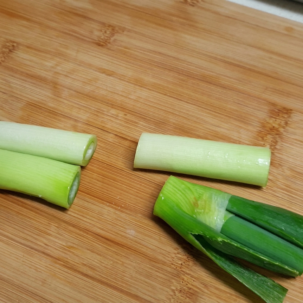 Ingredienti tra cui costine di manzo, ravanello e pezzi di cipolla aggiunti in una grande pentola piena dacqua.