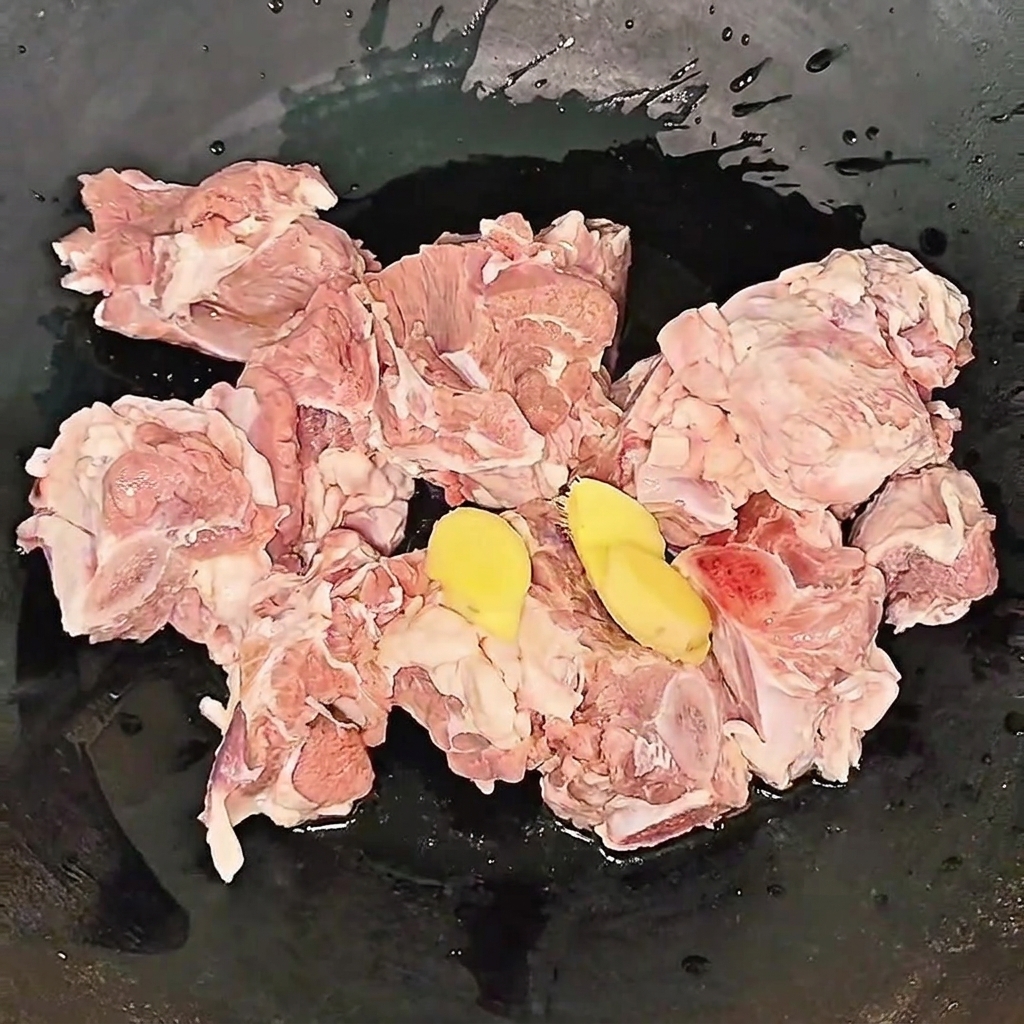 Costine di manzo che sobbollono in pentola con zenzero e vino durante la sbollentatura.