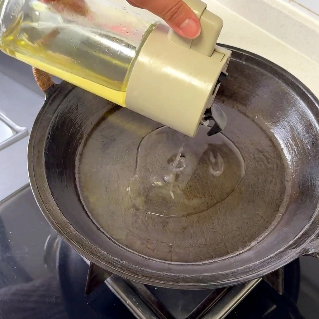 Un uovo fritto in una padella calda, con albumi spumosi e bordi dorati croccanti.