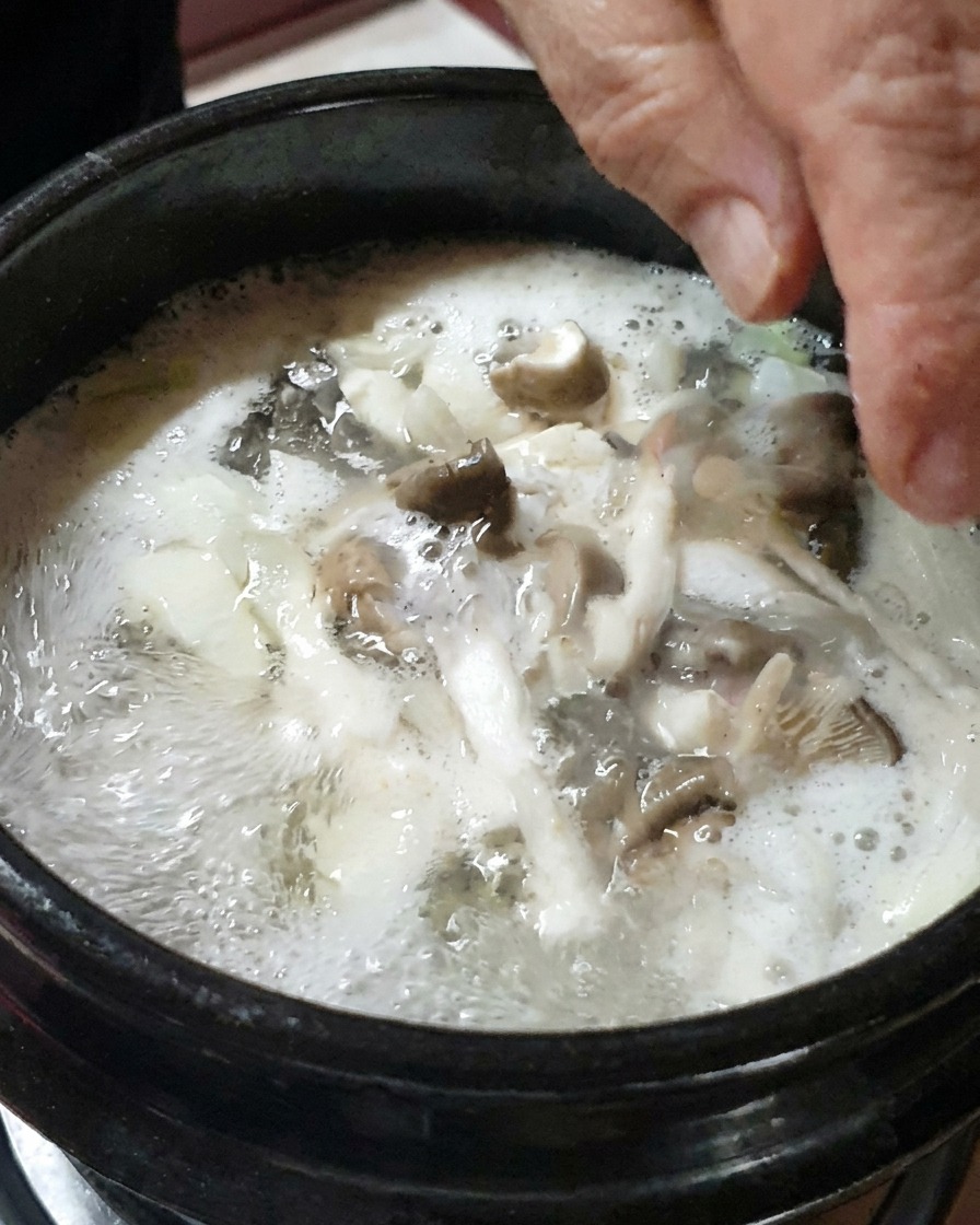 Cipolle a cubetti e funghi affettati che vengono aggiunti allo stufato.