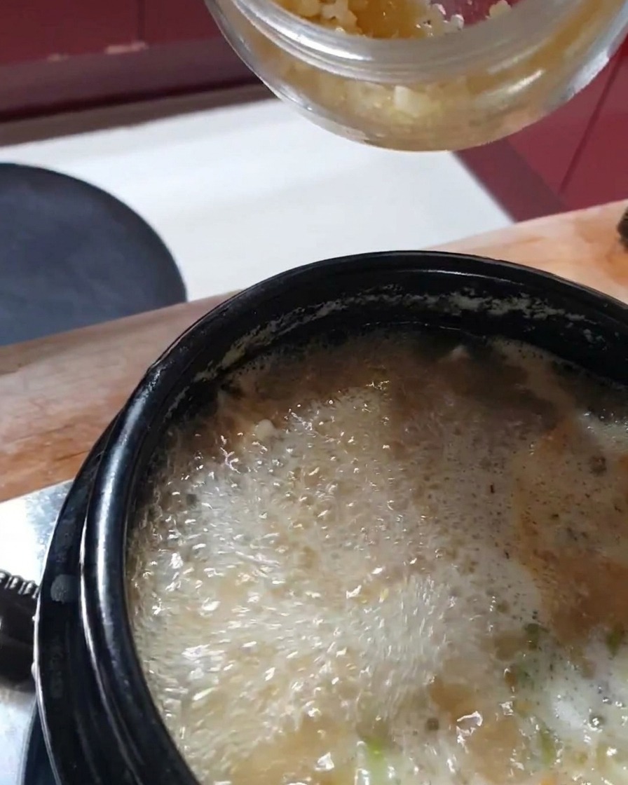 Un cucchiaio di aglio appena tritato aggiunto allo stufato fumante.