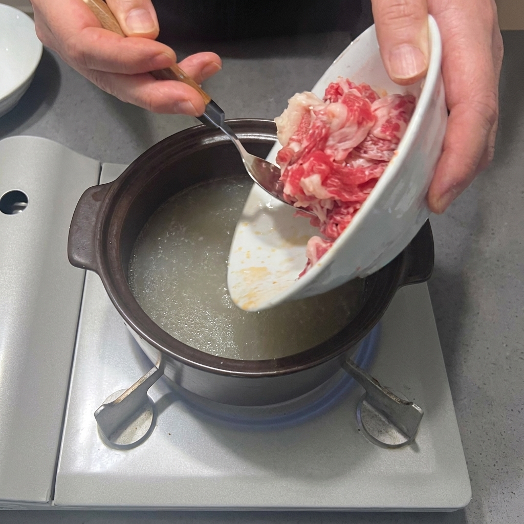 Fettine di punta di petto di manzo aggiunte alla pentola con il brodo.