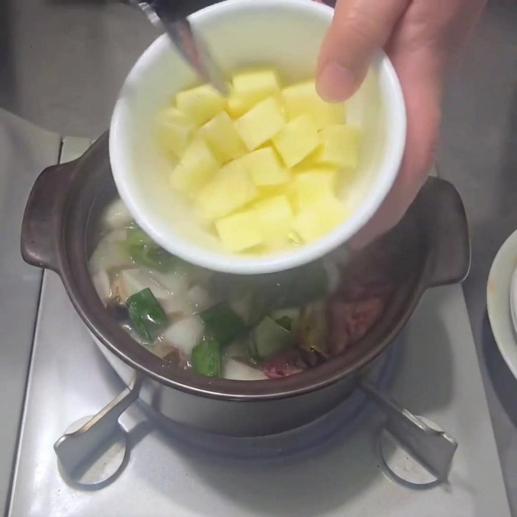 Patate a cubetti aggiunte nella pentola insieme alle altre verdure.