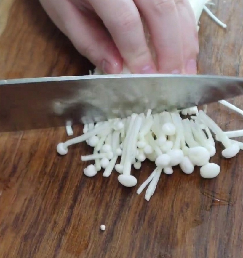 Sezioni di funghi enoki puliti pronti per essere aggiunti allo stufato.