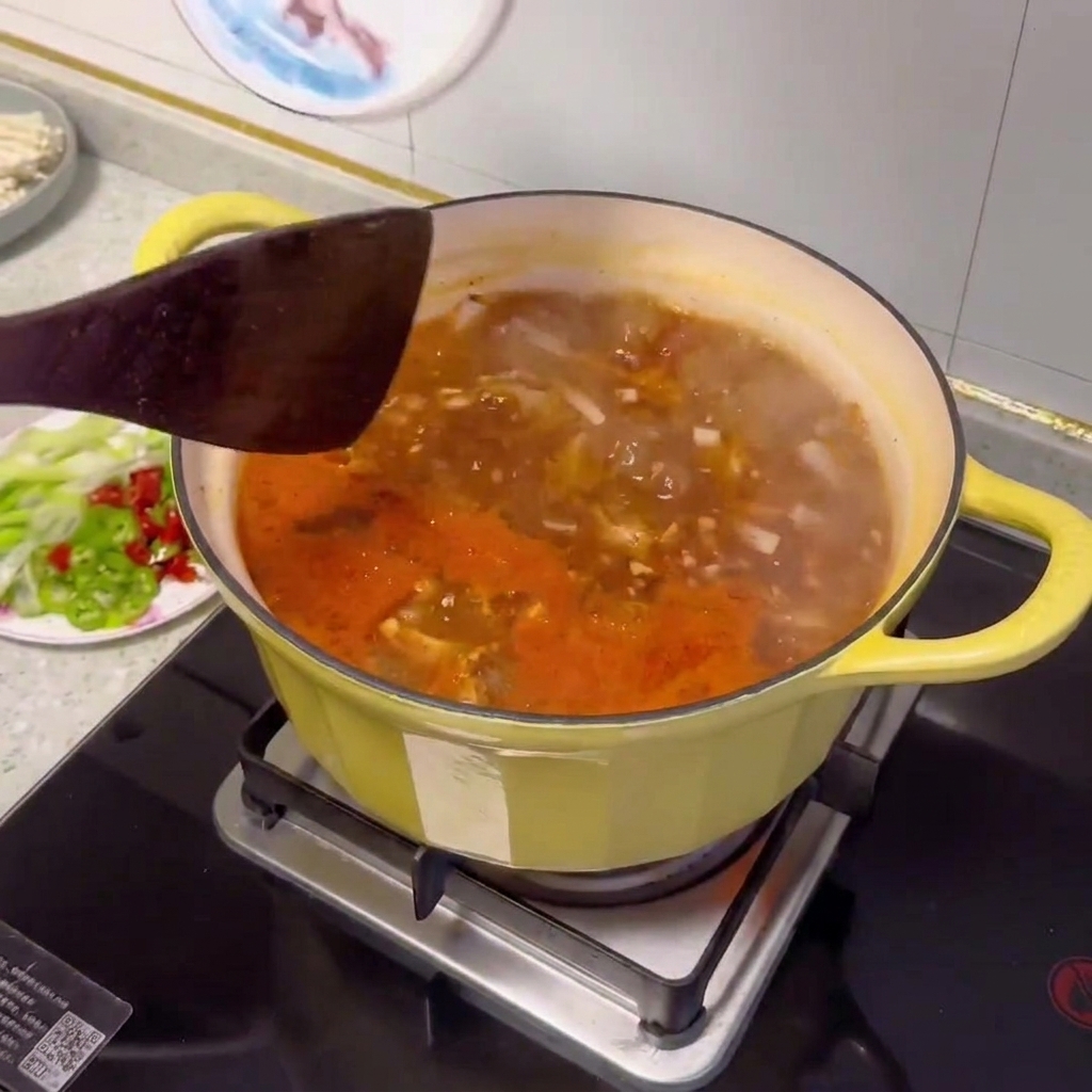 Varie verdure affettate e vongole che vengono aggiunte alla pentola dello stufato.