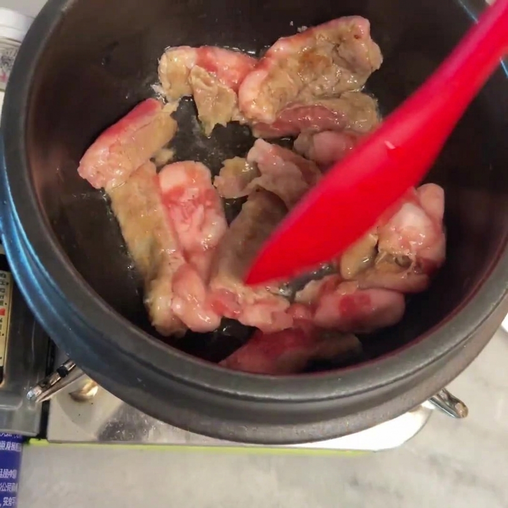 Manzo mescolato e rosolato nella pentola di pietra calda.