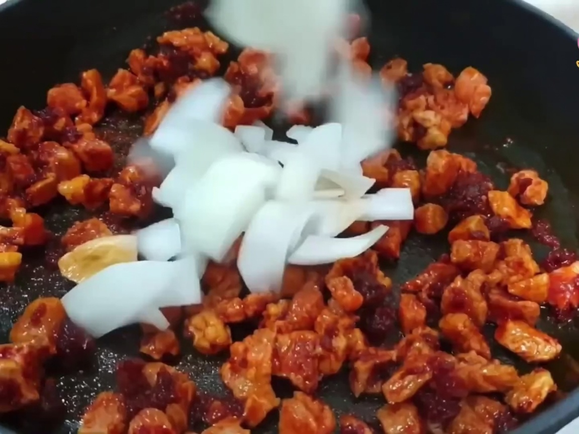 Cipolla, cipollotto e aglio aggiunti nella pentola con la carne.