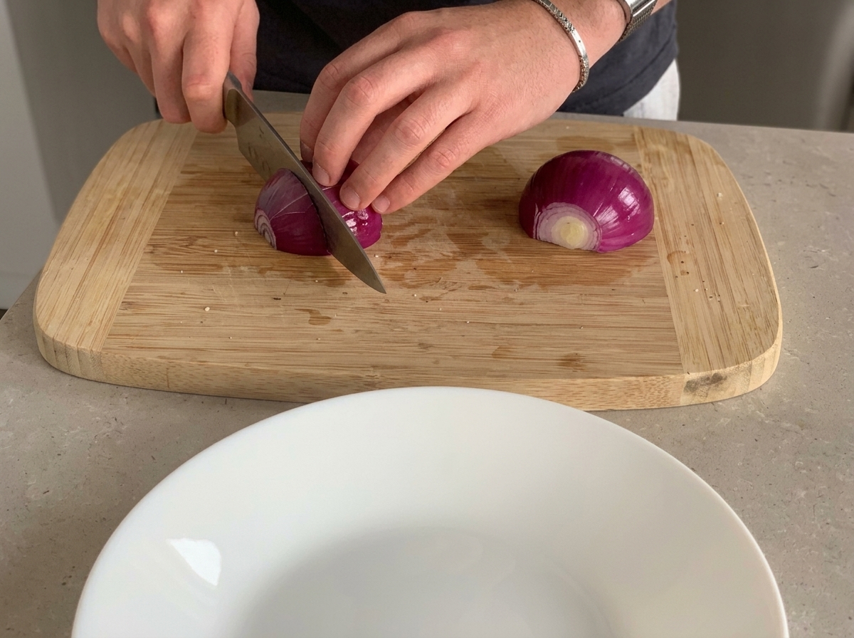 Cipolla rossa tagliata a piccoli pezzi su un tagliere di legno.