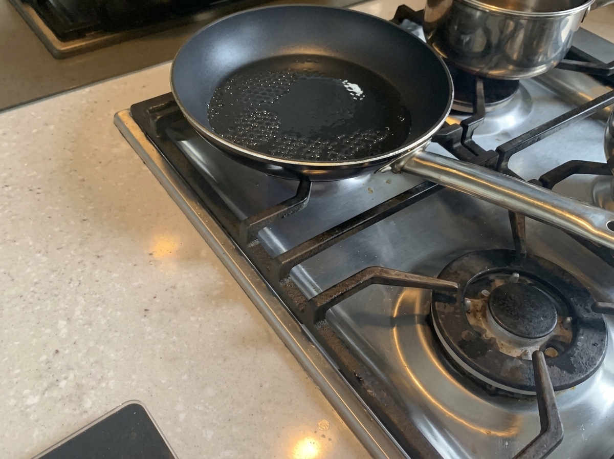 Cipolle tritate che soffriggono in padella con olio caldo finché non diventano tenere.
