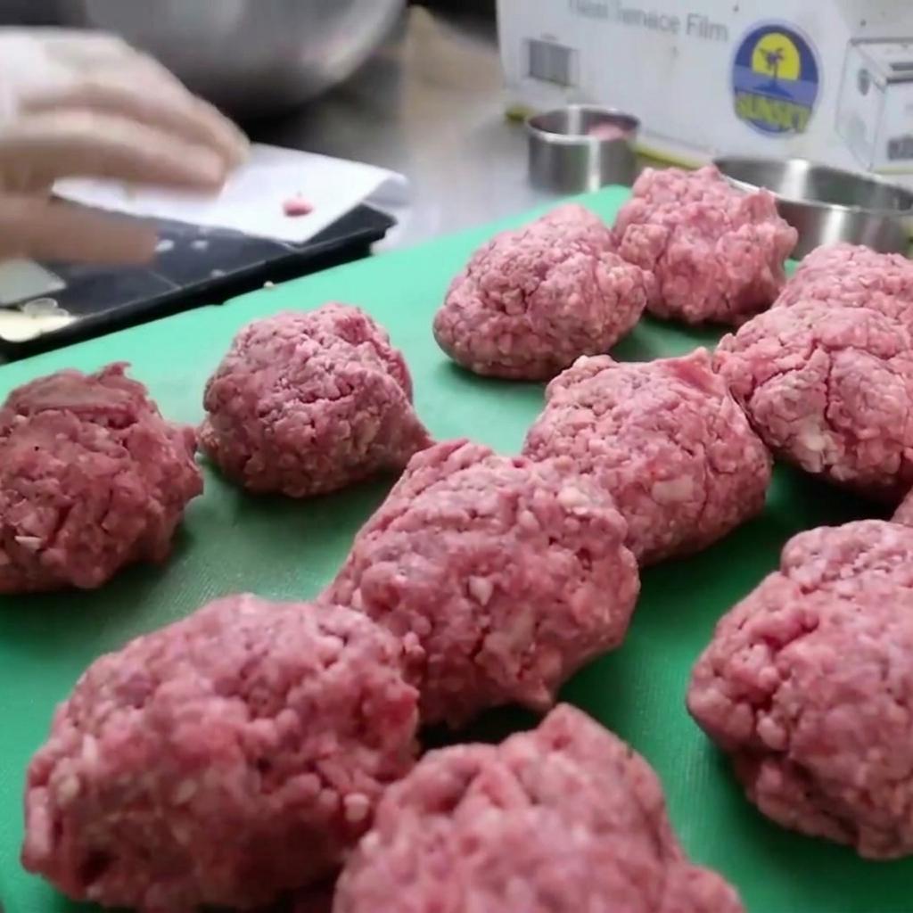 Carne di bisonte macinata pressata in uno stampo circolare per formare patty spessi.
