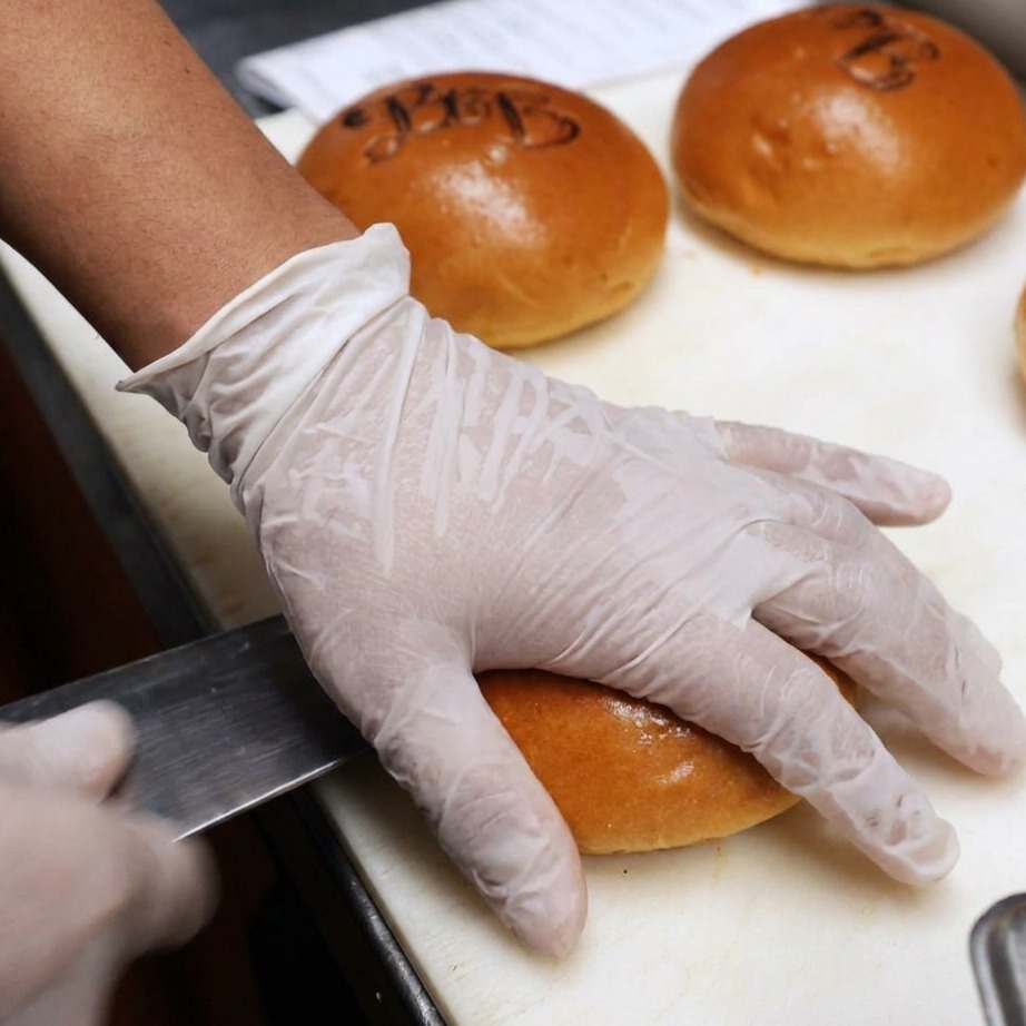 Panini per hamburger tagliati a metà e spalmati con burro per la griglia.