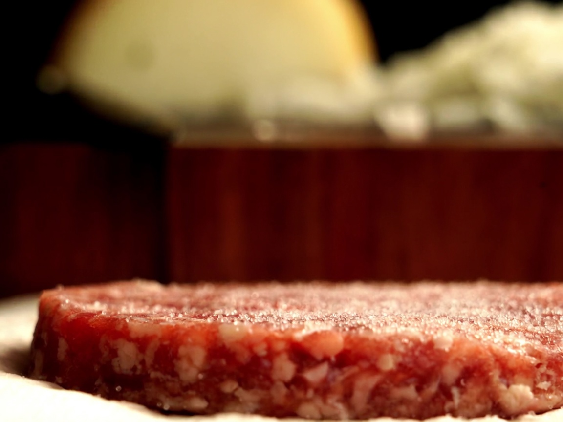 Primo piano di una polpetta di manzo Wagyu australiano condita con pepe nero fresco macinato.