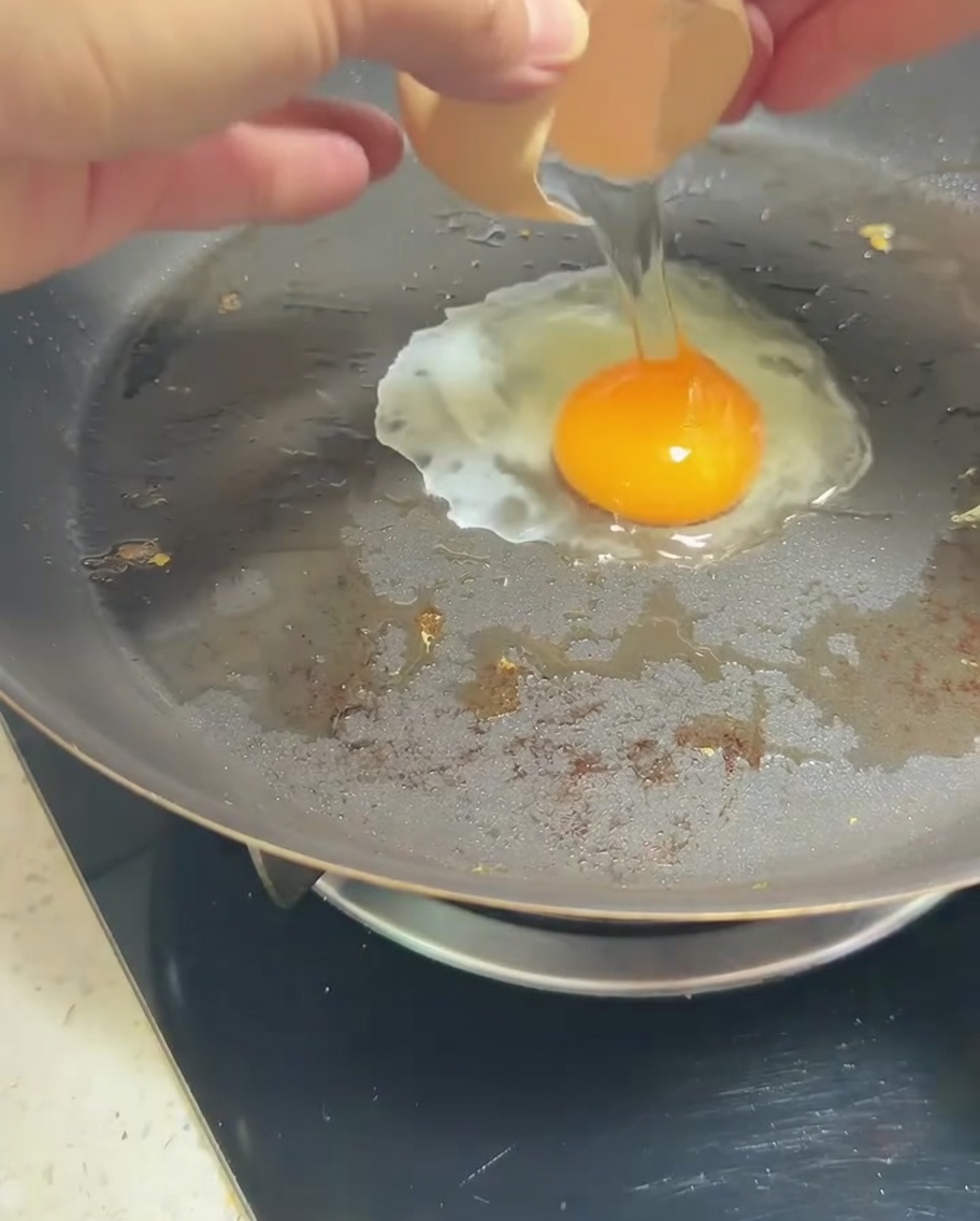 Un uovo in padella con il tuorlo dorato.
