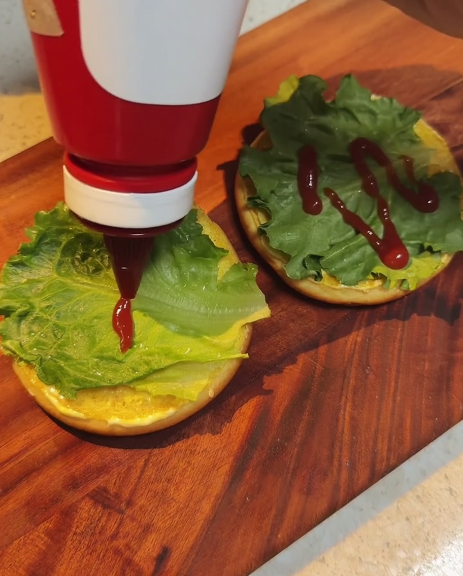 Ketchup rosso versato sopra la lattuga nel panino.