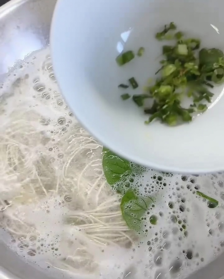 Zenzero tritato e coriandolo fresco sul fondo di una ciotola bianca.