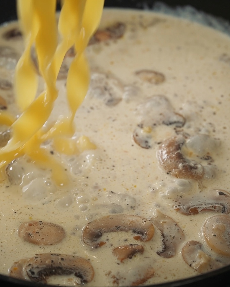 La pasta e la salsa al tartufo nero aggiunte in padella con la crema di funghi.