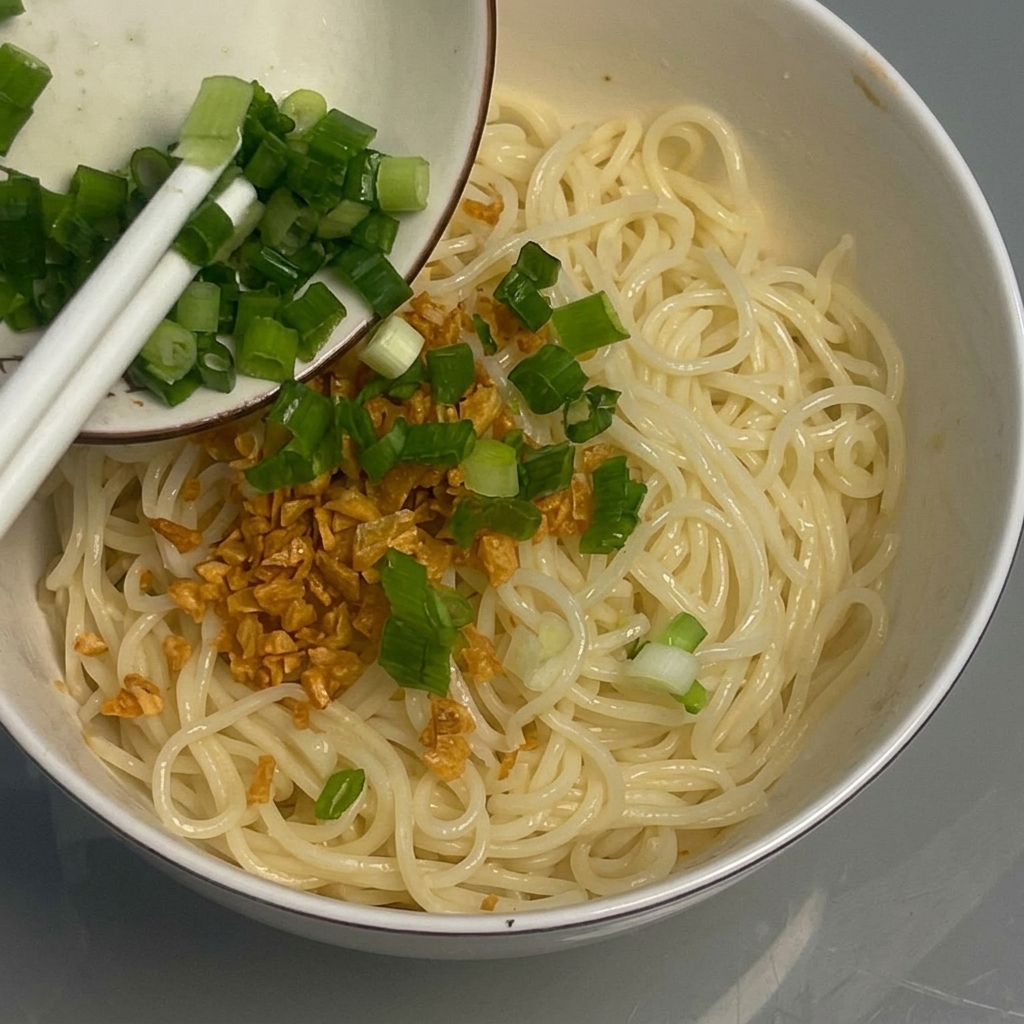 Cipollotti tritati aggiunti come guarnizione ai noodles.