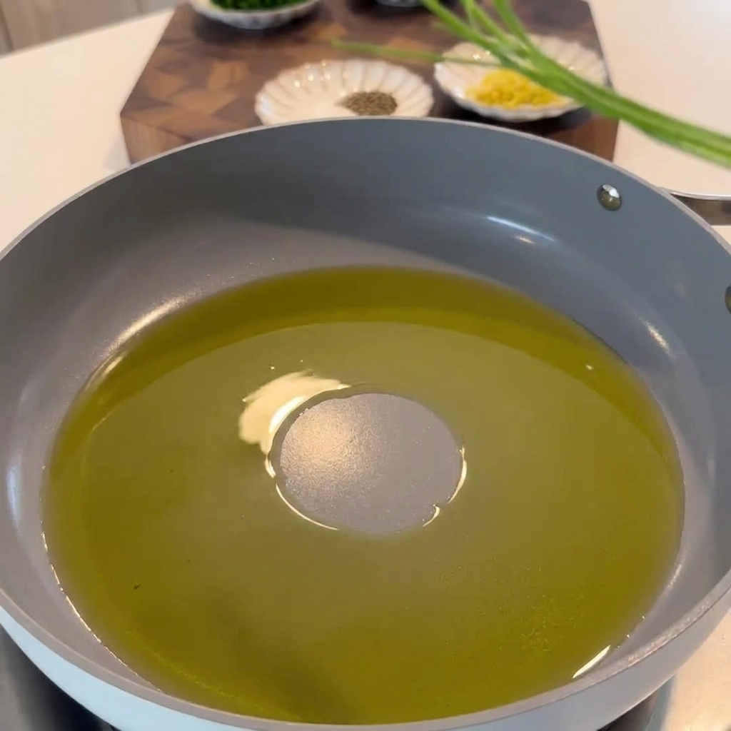 Gambi di prezzemolo, scorza di limone e peperoncino che soffriggono nellolio.