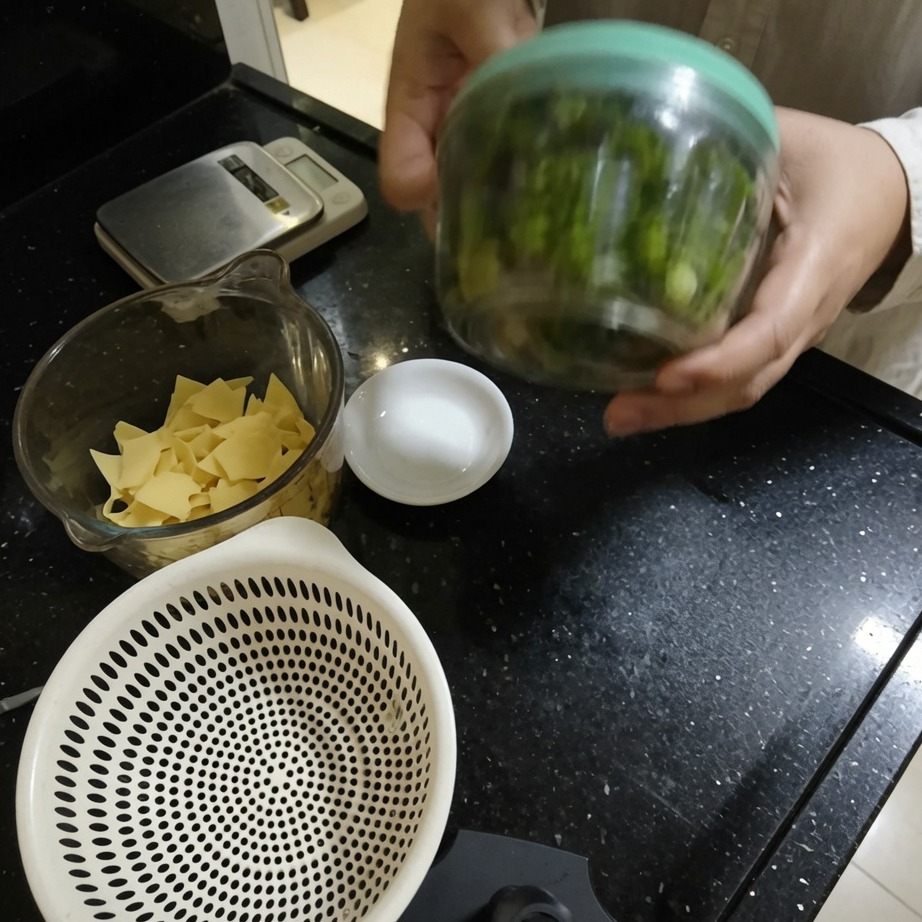 Una mano aziona un tritatutto manuale a corda per tritare le erbe.