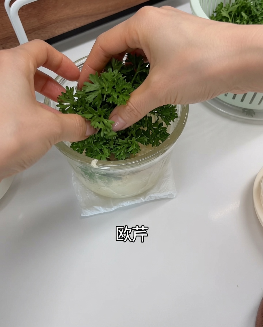 Foglie di prezzemolo verde fresco inserite nel robot da cucina sopra laglio e lo scalogno.
