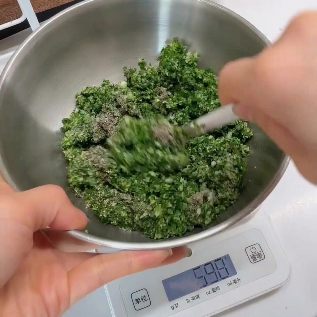 Primo piano del composto verde alle erbe mescolato in una ciotola dacciaio inossidabile con una spatola bianca.