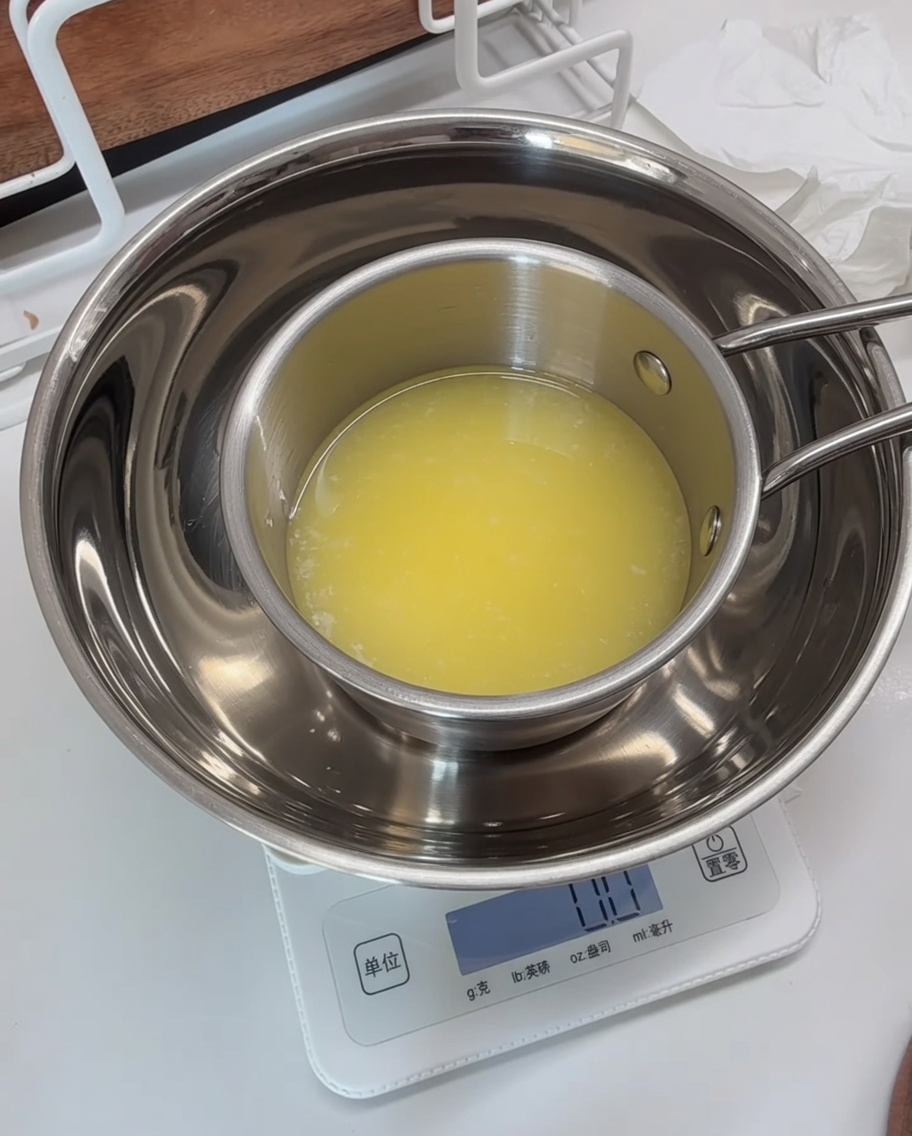 Una ciotola dosatrice di metallo su una bilancia digitale con il composto di prezzemolo combinato con burro fuso.
