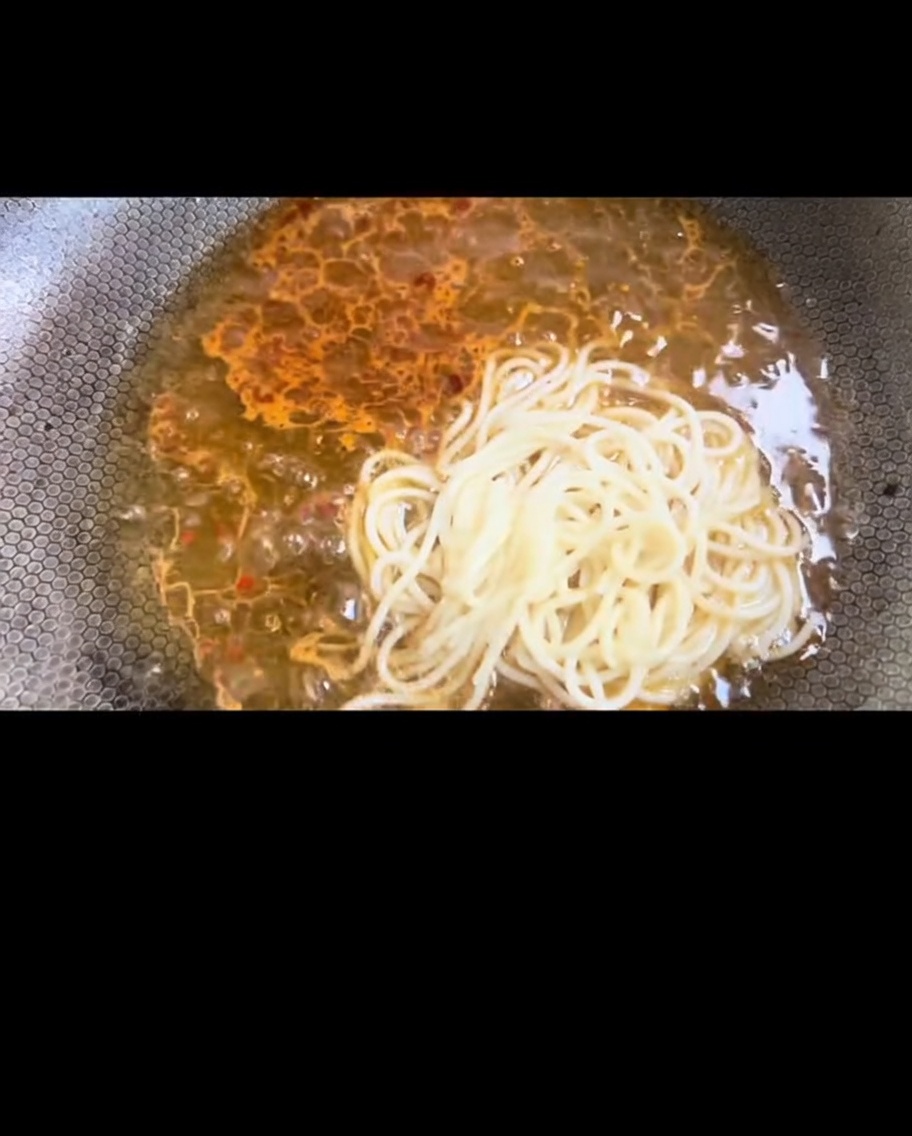 Spaghetti cotti trasferiti nella padella con il condimento.