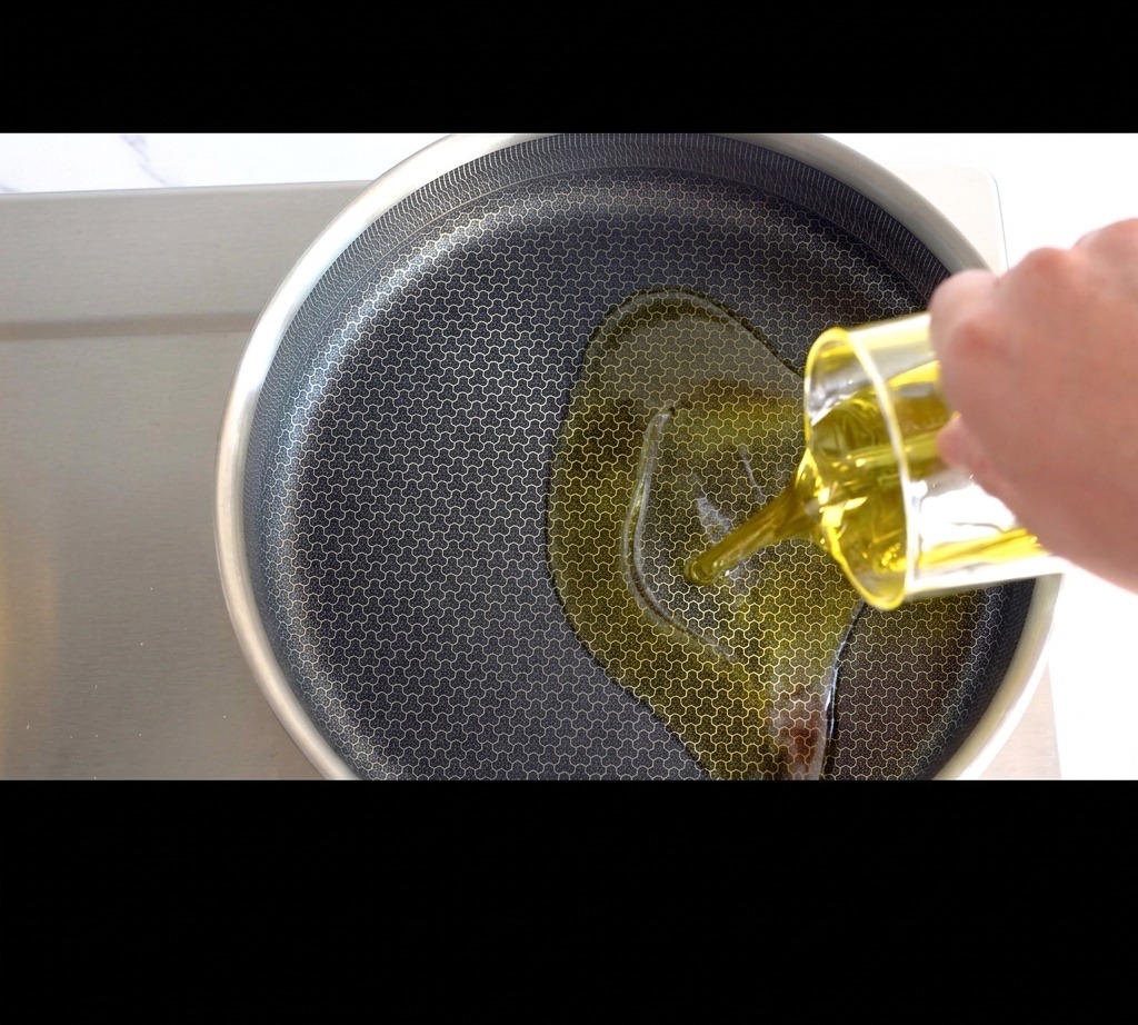 Olio doliva versato in una padella sul fuoco.