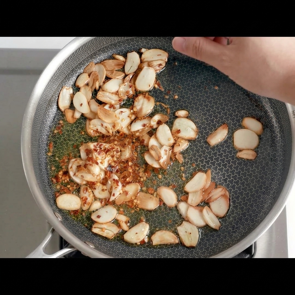 Pezzetti di peperoncino secco uniti in padella allaglio dorato.
