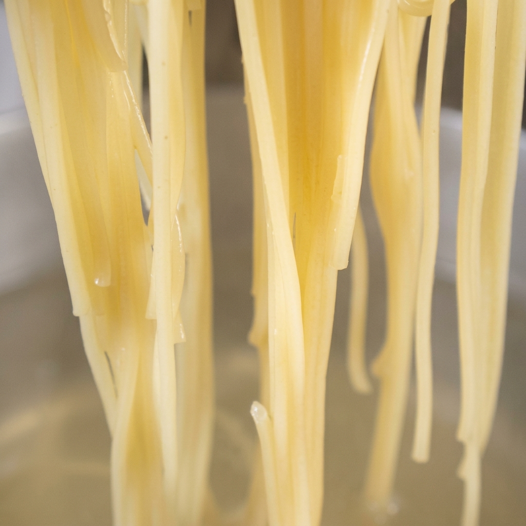Spaghetti cotti aggiunti direttamente in padella con lolio dorato allaglio e peperoncino.