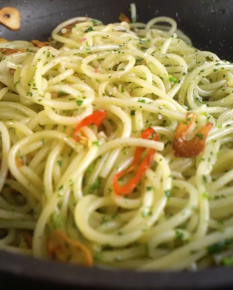 Sale e pepe nero appena macinato cosparsi sul piatto di pasta nella padella.