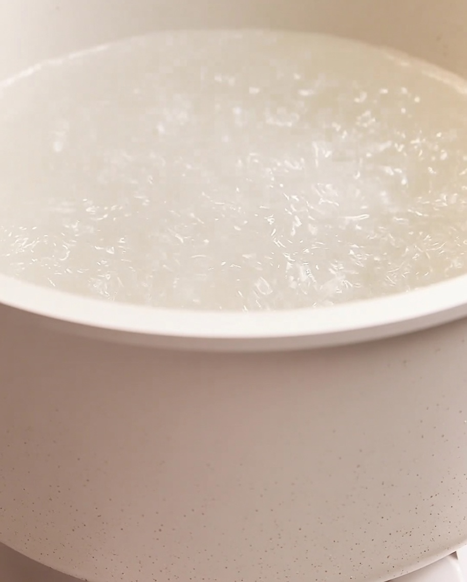 Spaghetti che cuociono in una grande pentola di acqua bollente.