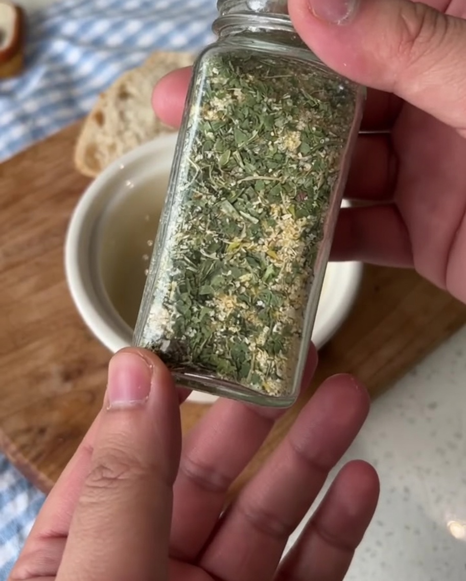 Una piccola ciotola in ceramica con burro ammorbidito mentre viene aggiunto il sale aromatizzato.