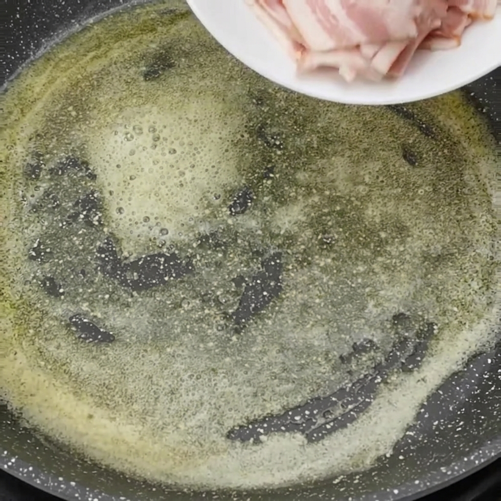 Pancetta cruda versata in una padella con burro fuso.