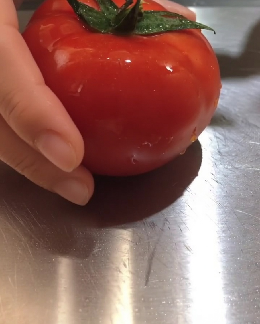 Pezzi di pomodoro fresco appoggiati su un tagliere.