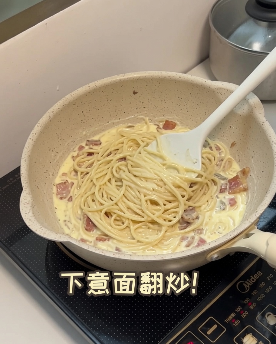 Spaghetti cotti saltati direttamente nel sugo cremoso in padella.