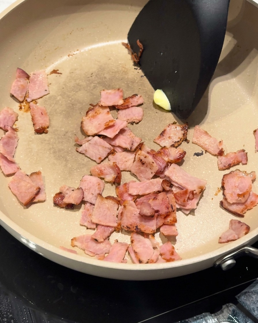 Un fiocco di burro che si scioglie nella padella insieme alla pancetta rosolata.